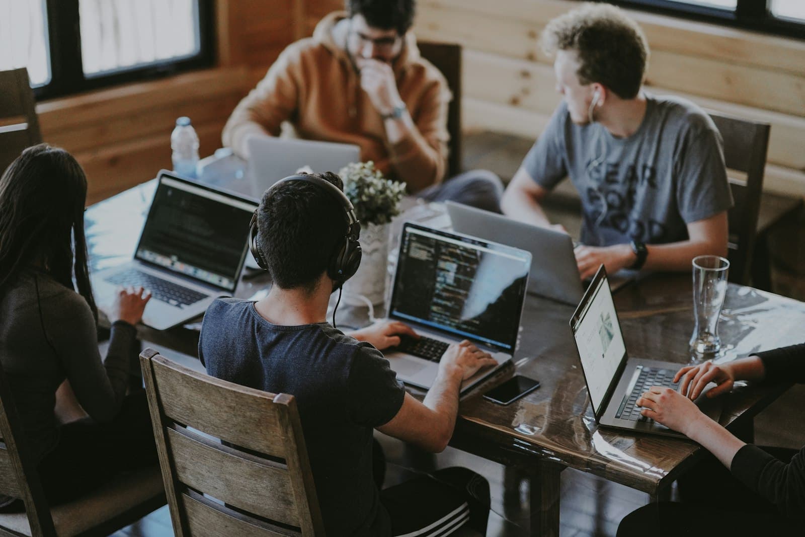 A team collaborating around laptops in a bright office