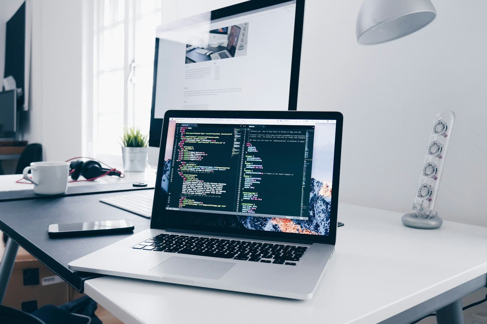 Code on a developer's screens in a dark room